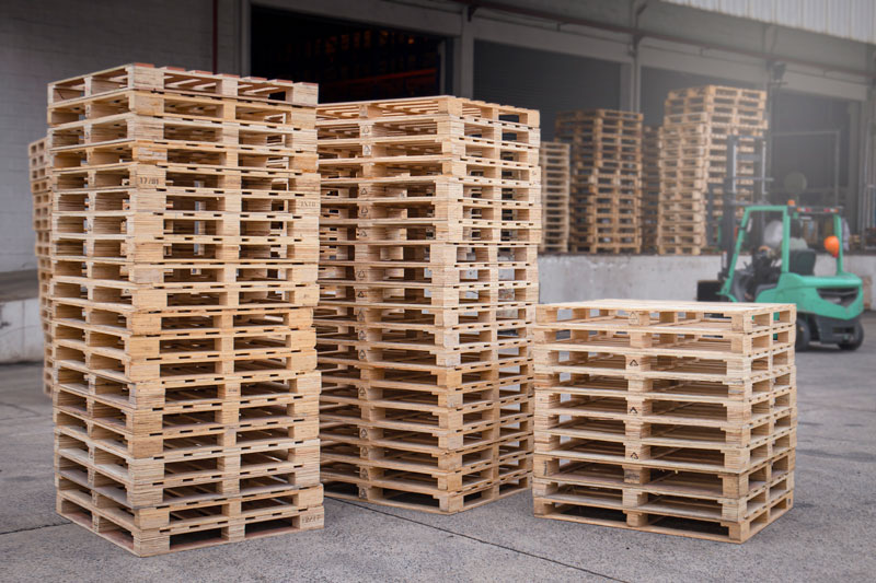 Stacks of pallets near forklift